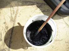 organic indigo hair dye paste ready to use, picture of indigo dye in a small white plastic tub, with a hint of purple sheen on top
