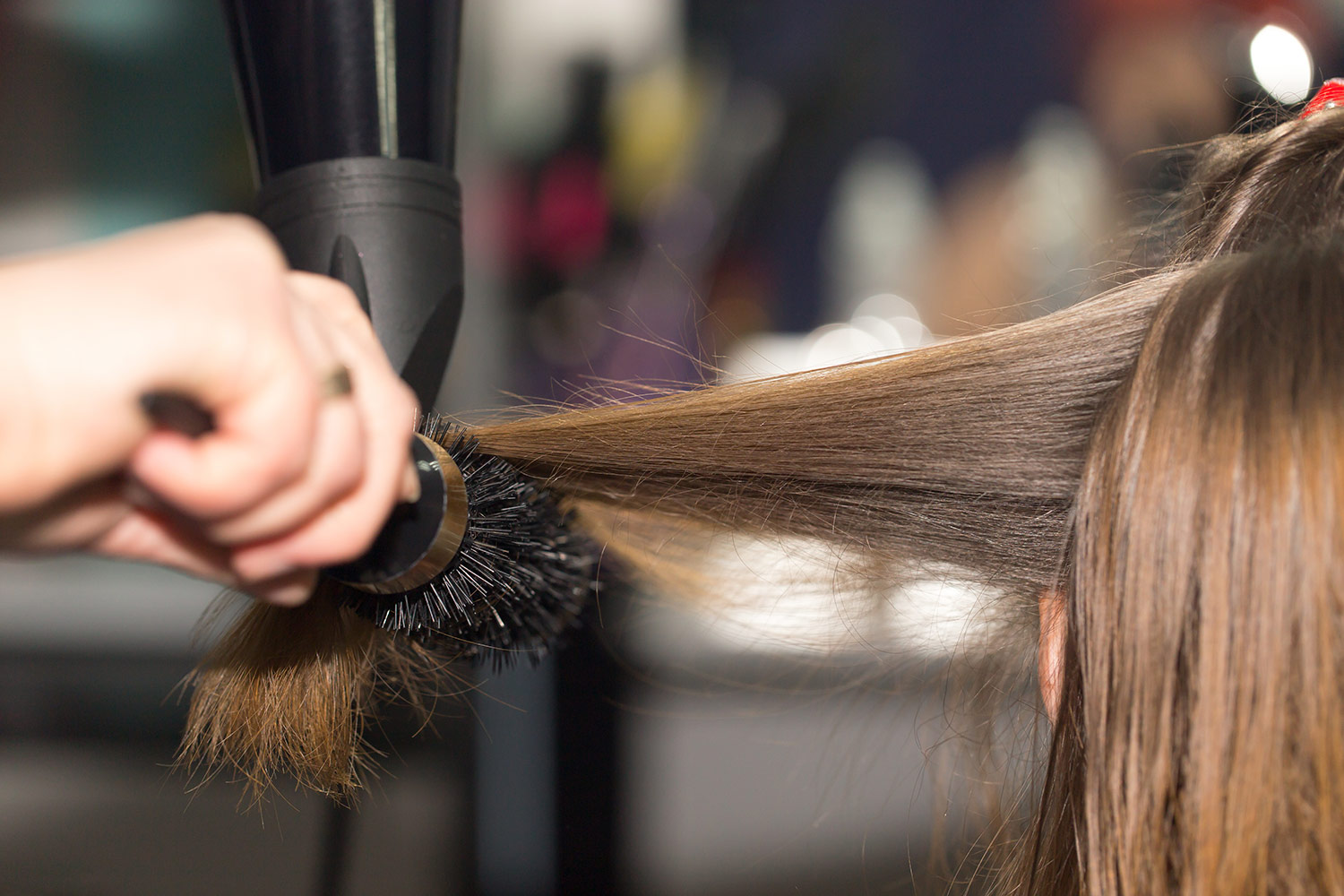 hair elasticity and dry hair, photo of hair being dried and styled, by stylist with hair brush