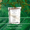 natural black hair dye product image of sealed foil packet of organic indigo powder, displayed against a green plant background and flower