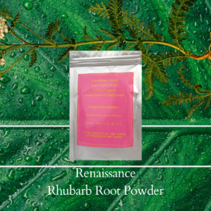 Natural golden highlights rhubarb root powder in sealed foil packet with pink label, displayed against a green leaf and plant background
