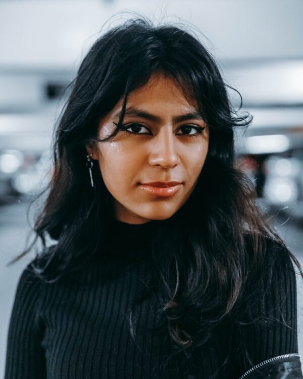herbal henna indigo in long wavy black hair on black woman wearing black jumper hair