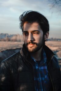 Profile of dark haired bearded man, head and shoulders, looking to the side . Dark brown black hair colour for men 