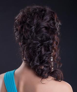Beautiful woman with rich brunette hair - long shiny hairstyle on black background, healthy curly hair dark brown black hair colour