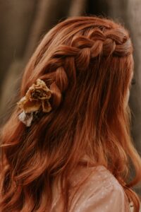 dark auburn hair colour, Image of back of woman's head with medium length auburn hair plaited in the middle 