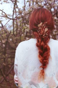 woman with organic henna hair dye on long braided hair, back view of her over her back