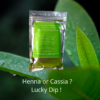 Henna cassia product packet, sealed foil pouch with green colour label displayed against green leaves background