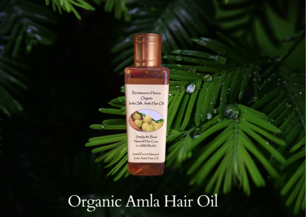 organic amla hair oil for healthy hair , product image against green leaves background