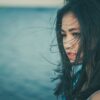 natural hair colour is beautiful hair colour from plants; woman with long wind swept natural black hair standing by the sea