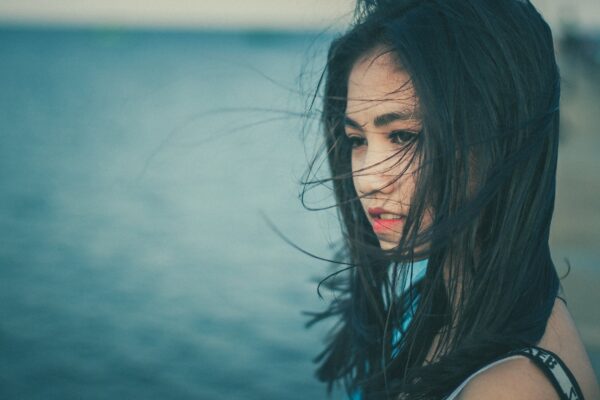 natural hair colour is beautiful hair colour from plants; woman with long wind swept natural black hair standing by the sea
