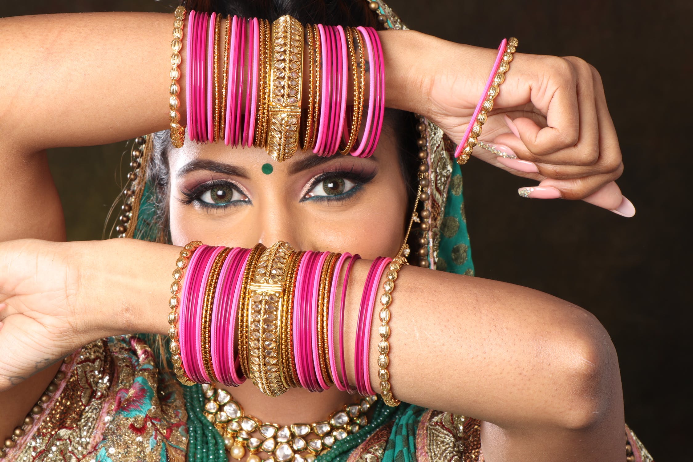 Indian Bags and Throws made from Recycled Saris, photo of INdian woman with arms decorated with colourful bracelets held across her face