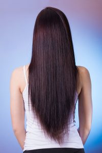 plant-based hair dye is organic, picture of back of woman with long straight dark hair wearing a sleeveless white dress
