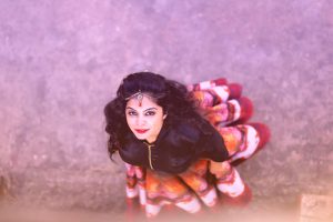 Best quality henna and indigo Renaissance Henna, woman with long black hair and colourful swirly skirt looking up