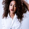Natural hair; henna and indigo on natural afro caribbean hair; beautiful woman wearing a white shirt, with wavy, long, thick hair