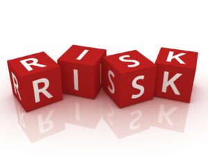 four red dice blocks each with a letter of the alphabet spelling RISK, depicting the risk of using chemical hair dye